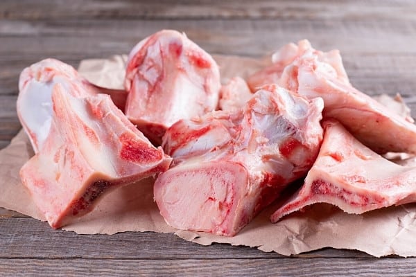 Raw beef bones on butcher paper ready to be made into bone broth.